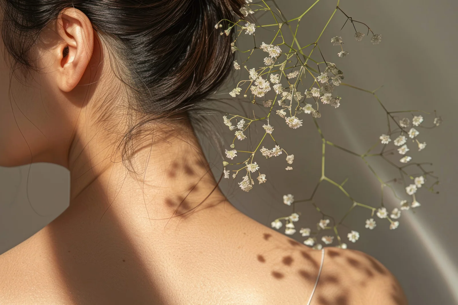 Delicate white flowers woven into bridal hair, lit by warm sunlight